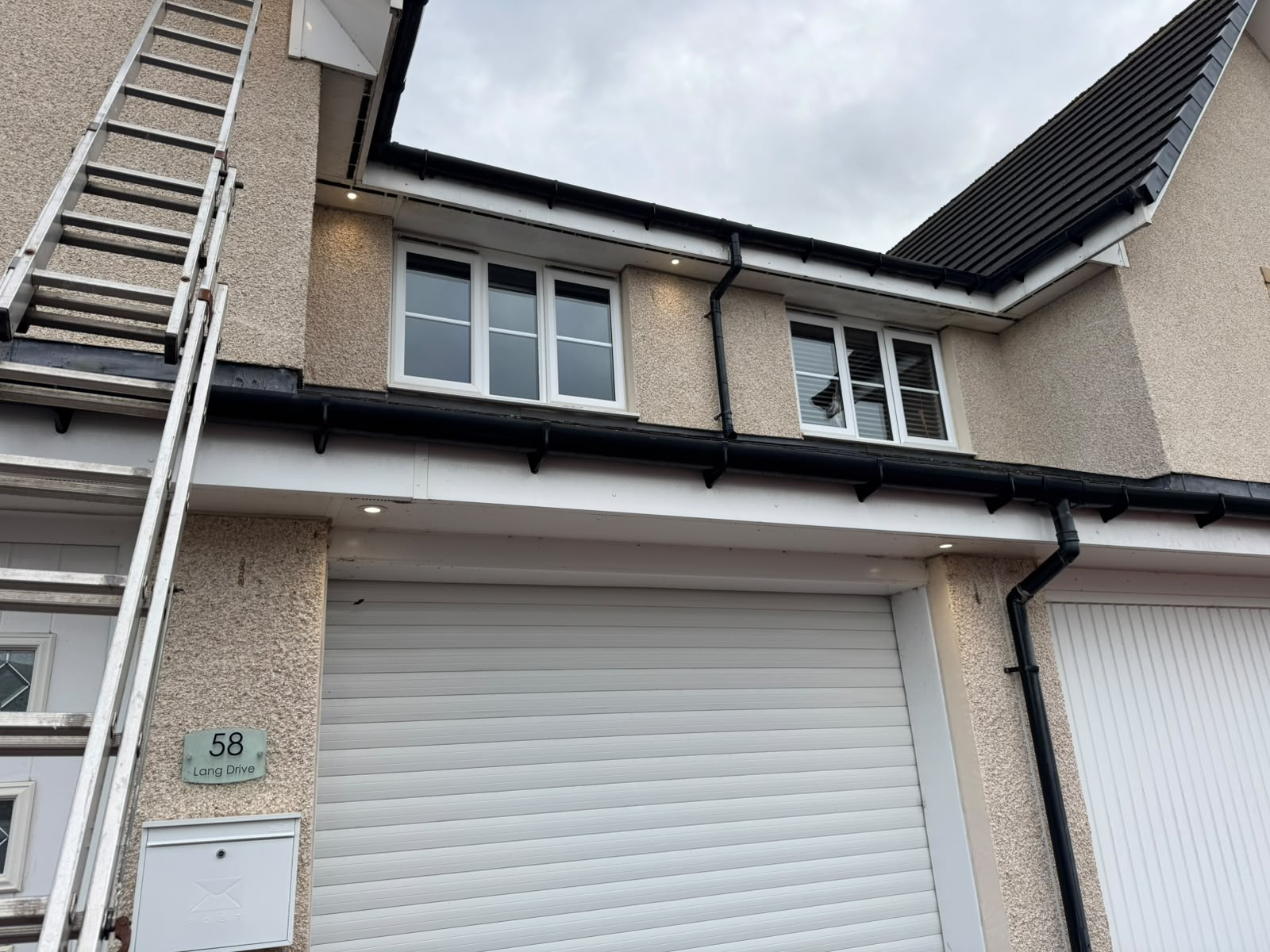 Daytime soffit downlights installed under the eaves of a domestic property